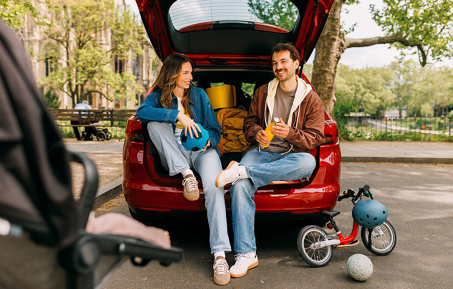 Kampagnen-Motiv Familie Carsharing Eltern mit Kinderfahrrad und Gepäck im Carsharing-Transporter