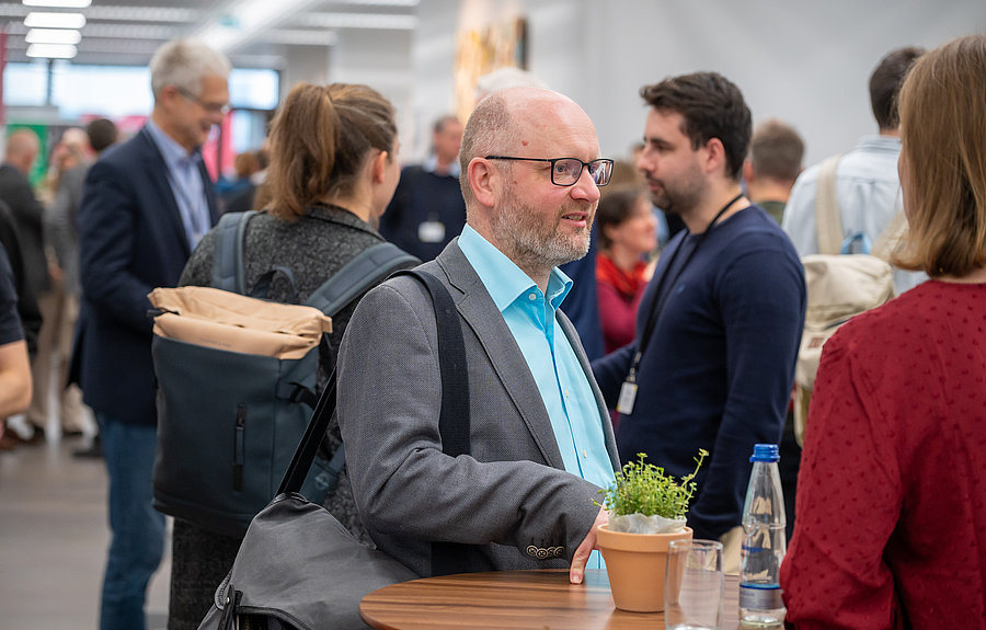 Menschen stehen in einem Foyer und unterhalten sich